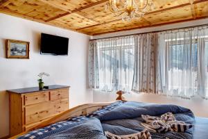 a bedroom with a bed and a tv and windows at Ferienwohnung Lapislazuli in Mittenwald