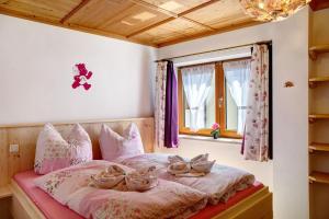 a bedroom with a bed with pink sheets and a window at Ferienwohnung Lapislazuli in Mittenwald