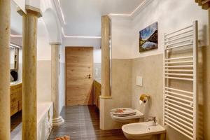 a bathroom with a sink and a toilet and a tub at Ferienwohnung Lapislazuli in Mittenwald +22 photos