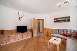 a living room with a couch and a flat screen tv at Ferienhaus Hof am Schloss in Prato allo Stelvio
