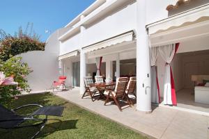 a patio with chairs and a table on a house at Large apartment in Vale do Lobo in Almancil