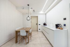 a kitchen with a wooden table and white cabinets at App 206 Palazzo Cavour in Bolzano