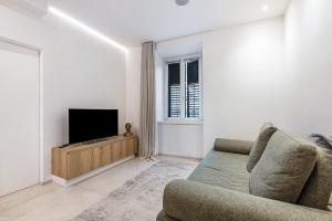 a living room with a couch and a television at App 206 Palazzo Cavour in Bolzano