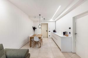 a kitchen and dining room with white walls and a table at App 206 Palazzo Cavour in Bolzano +7 photos