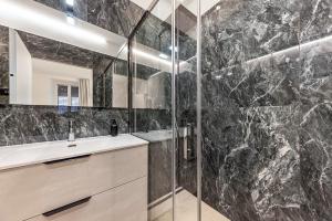 a bathroom with a shower and a sink and a mirror at App 206 Palazzo Cavour in Bolzano