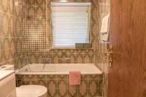 a bathroom with a tub and a toilet and a window at Ferienwohnung Lilly in Garmisch +14 photos