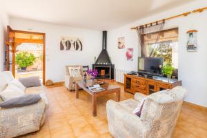 a living room with a couch and a tv at Ses Serres in Santanyi
