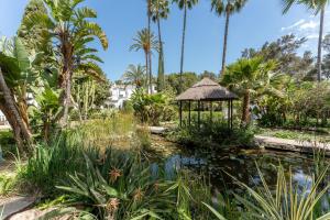 a garden with a pond and a gazebo at Casa Karma in Mijas