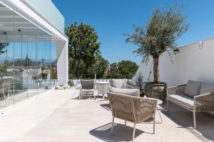 a patio with chairs and a tree on it at Casa Blanca in Torre del Mar