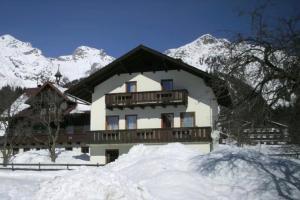 a large building with a balcony in the snow at Landlhof in Ramsau