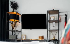 a room with a tv and a bed with a lamp at Flora und Fauna by Kamelu in Gengenbach