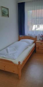 a wooden bed in a room with a window at Landlhof in Ramsau