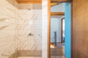 a bathroom with a walk in shower with marble tiles at Mirage Arillas Maisonette A in Arillas +17 photos
