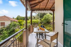 a patio with a table and chairs on a balcony at Nikoleta Apartment 2 in Nikiana