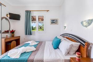 a bedroom with a bed with blue and white pillows at Nikoleta Apartment 2 in Nikiana