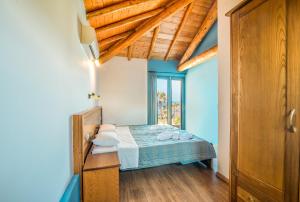 a bedroom with a bed with blue walls and wooden floors at Mirage Arillas Maisonette A in Arillas