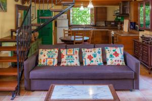 a living room with a purple couch with pillows at Acuario-Géminis in Llucmajor