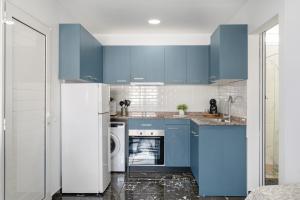 a kitchen with blue cabinets and a washer and dryer at Casa sofia in Arrecife