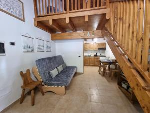a living room with a staircase and a dining room at Appartamento Adamello 11 in Pinzolo
