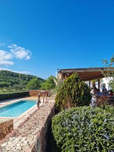 ein Swimmingpool mit einer Steinmauer neben einem Haus in der Unterkunft El Ton Golf in Son Parc