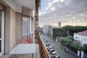 a balcony with a table and cars parked on a street at Albenga Mary 43 6 in Albenga