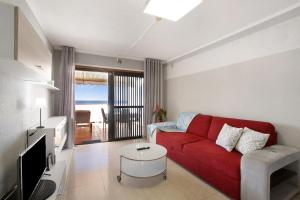 a living room with a red couch and a tv at Las Fuentes in Arona