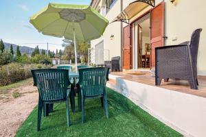 two chairs and a table with an umbrella on a patio at Casa Elisa in Padru