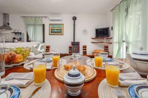 a wooden table with plates and glasses of orange juice at Casa Elisa in Padru