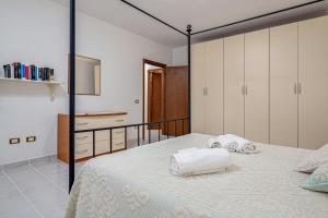 a bedroom with a bed with two towels on it at Casa Elisa in Padru