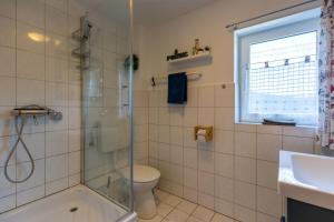 a bathroom with a shower and a toilet and a sink at Ferienhof An Der Wehle Pellworm in Pellworm +14 photos