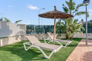 two lounge chairs and an umbrella on a lawn at Casa Isabel in El Verger