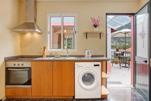 a kitchen with a washing machine and a sink at São Vicente House in São Vicente