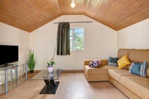 a living room with a couch and a tv at São Vicente House in São Vicente