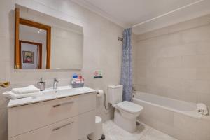 a bathroom with a sink and a toilet and a tub at Suite Cava in Arrecife