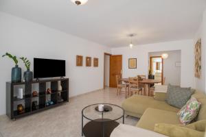 a living room with a couch and a tv at Suite Cava in Arrecife