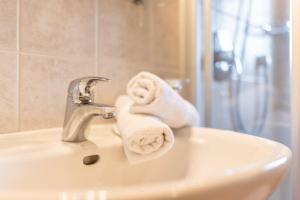 a bathroom sink with a faucet with towels on it at Oberplunerhof - Fewo Bruneck in Colli in Pusteria