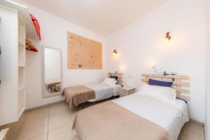 a bedroom with two beds and a mirror at Es Cantonet in Porto Cristo