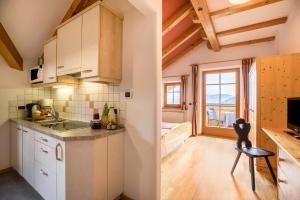 a kitchen with white cabinets and a view of a room at Oberplunerhof - Fewo Bruneck in Colli in Pusteria +37 photos