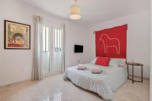 a bedroom with a bed with a red headboard at Suite Cava in Arrecife