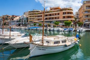a group of boats docked in a marina with buildings at Es Cantonet in Porto Cristo