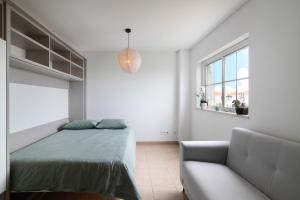 a white bedroom with a bed and a couch at Vista Mar in Cabanas de Tavira