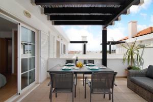 a dining room with a table and chairs on a patio at Vista Mar in Cabanas de Tavira