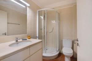 a bathroom with a shower and a toilet and a sink at Casa do Ouriço - Cabanas Tavira in Tavira +21 photos