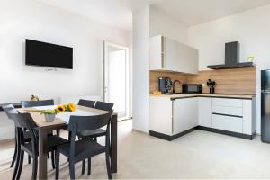 a kitchen and dining room with a table and chairs at Helianthus in Cisternino