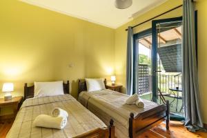 two beds in a room with a balcony at Villa Koutoupakia in Kefallonia