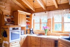 a kitchen with wooden cabinets and a vase of flowers at Ferienwohnung am Hirschenmoor in Breitnau +33 photos
