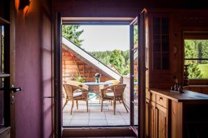 an open door to a patio with a table and chairs at Ferienwohnung am Hirschenmoor in Breitnau