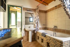a bathroom with a bath tub and a sink at Villa Koutoupakia in Kefallonia
