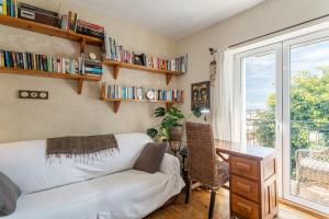 a living room with a couch and a desk and a window at Casita Kunterbunt in Alicante