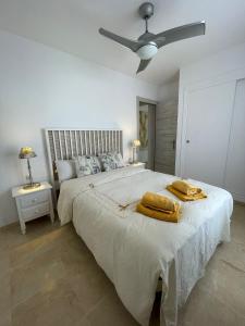 a bedroom with a large bed with two towels on it at El Portil Pinares in El Portil +19 photos